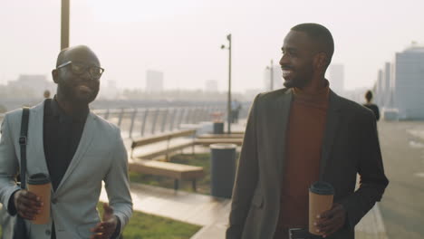 Afroamerikanische-Geschäftsleute,-Die-Draußen-Mit-Kaffee-Spazieren-Gehen-Und-Reden